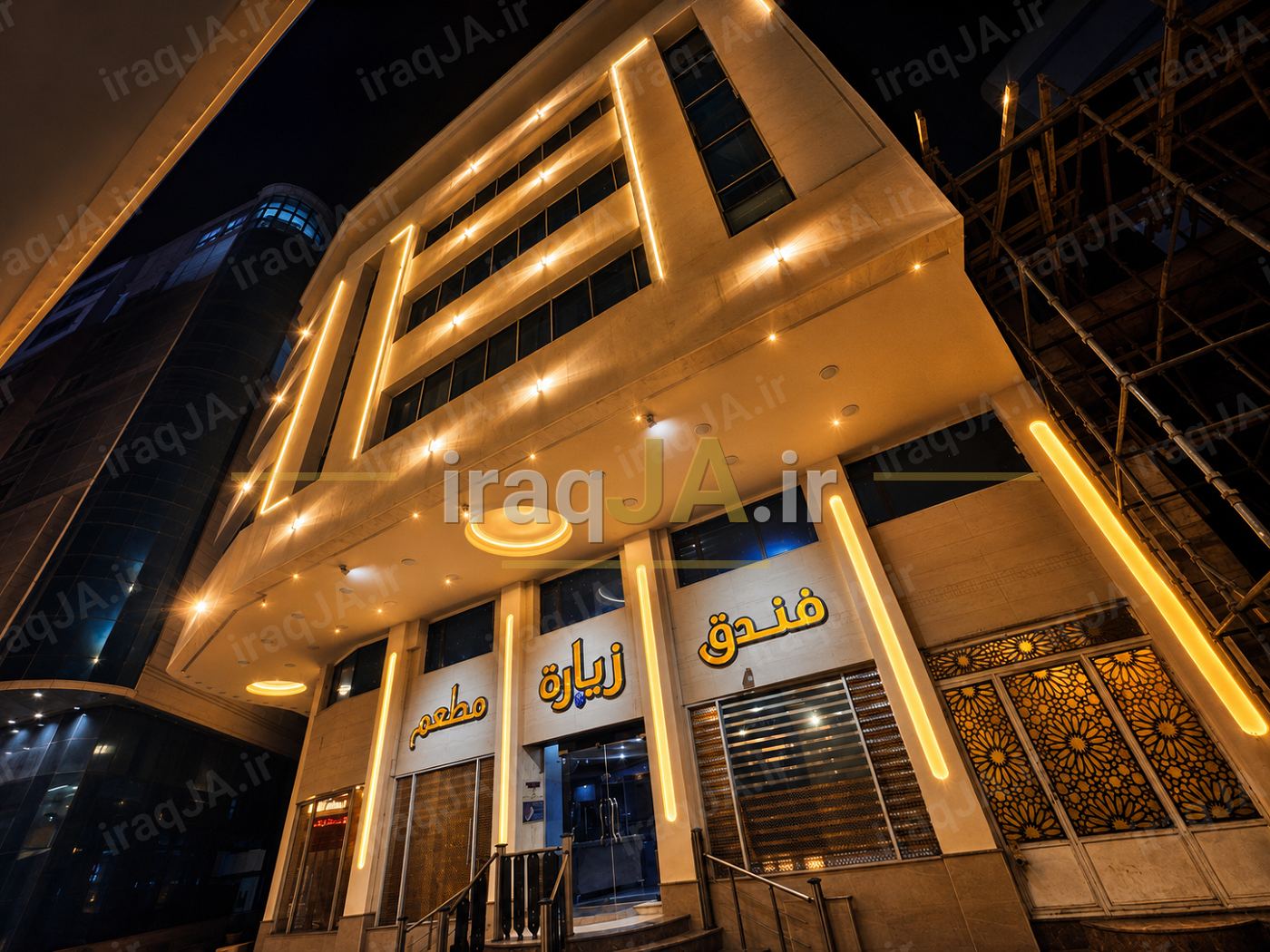 نمای شبانه هتل زیاره با نورپردازی طلایی و تابلوی «فندق زیارة» بالای ورودی